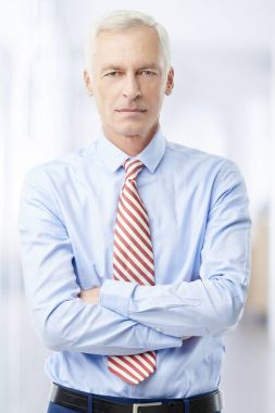 Kendine güvenen üst düzey adam geçti ve kameraya seyir silah ile ayakta.