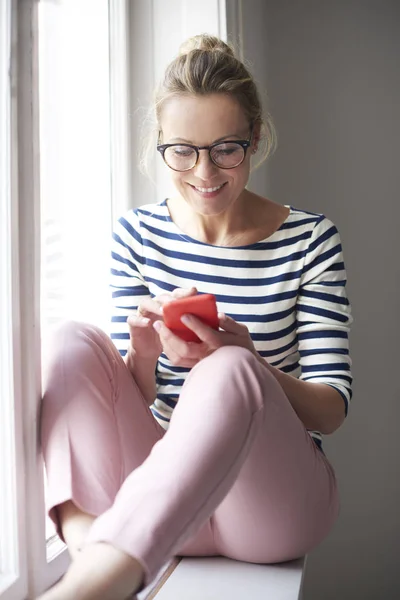 Glückliche Gelegenheitsfrau Die Ihr Handy Und Sms Benutzt Während Sie — Stockfoto