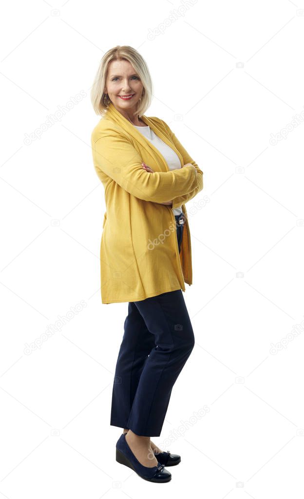 Full length of attractive mature woman smiling at the camera while standing against at isolated white background.
