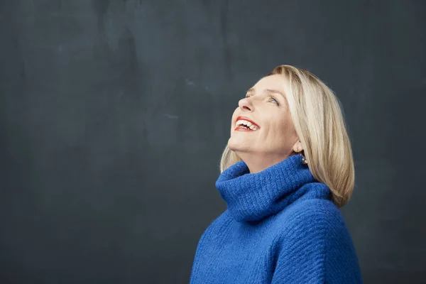 笑成熟的女人站在灰色背景 — 图库照片