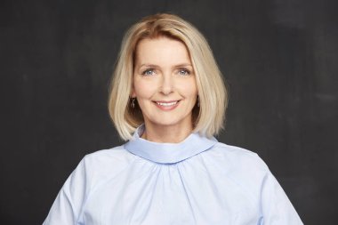 Sana bakmak ve koyu arka plan, dururken gülüyor güzel Olgun kadın.