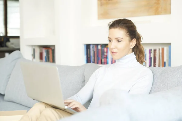 Atractiva Mujer Sonriente Usando Portátil Mientras Relaja Casa Sofá —  Fotos de Stock