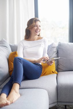 Güzel orta yaşlı kadın evde iyi bir kitap okuma.