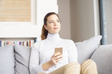 Esmer Olgun kadın kanepe ve onu cep telefonundan mesaj dinlenirken düşünceli arıyorum.