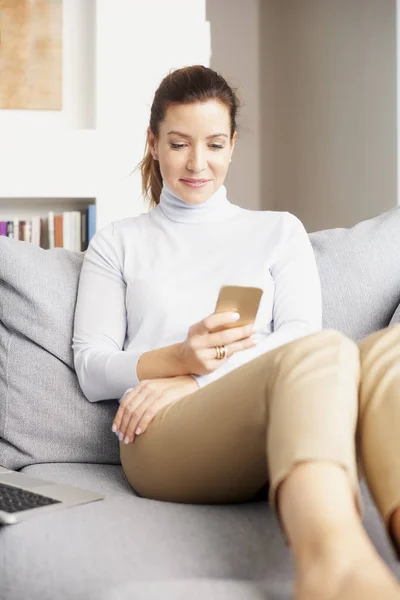 Sonriente Morena Madura Mujer Relajándose Sofá Mensajes Texto Teléfono Celular — Foto de Stock