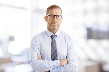 Silah ile ayakta ofiste geçti ise gömlek ve kravat giyen orta yaşlı işadamı portresi.