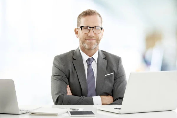 Uitvoerend Zakenman Met Armen Gekruist Aan Het Bureau Zitten Kijken — Stockfoto