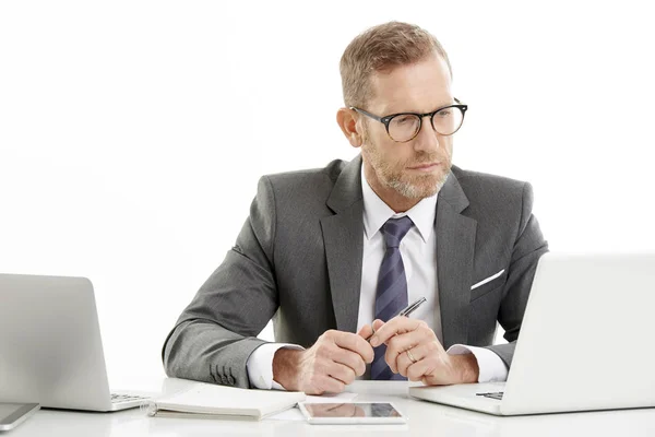 一个中年财务总监的工作室肖像坐在办公桌和使用笔记本电脑 具有复制空间的独立白色背景 — 图库照片