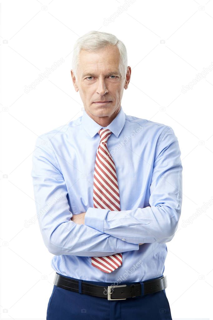 A serious businessman wearing shirt and tie and while standing against at isolated white background.
