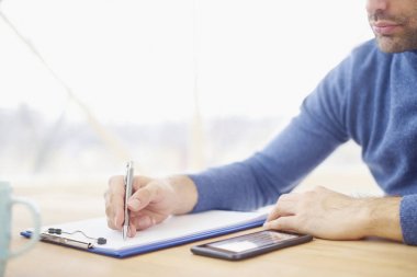 Businessmans el somesthing kağıda yazı close-up. Resepsiyon ve dolgu formu oturan rahat profesyonel adam. Ön plan üzerinde odaklanmak. 