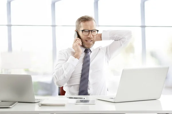 Confindent 中年商人穿着衬衣 打领带 坐在笔记本电脑前打电话 在办公室工作 — 图库照片