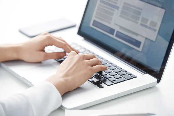 Masada oturan ve yeni proje üzerinde çalışma sırasında dizüstü bilgisayarınızın klavyede yazarak işkadını'nın el close-up. Beyaz arka plan üzerinde izole.