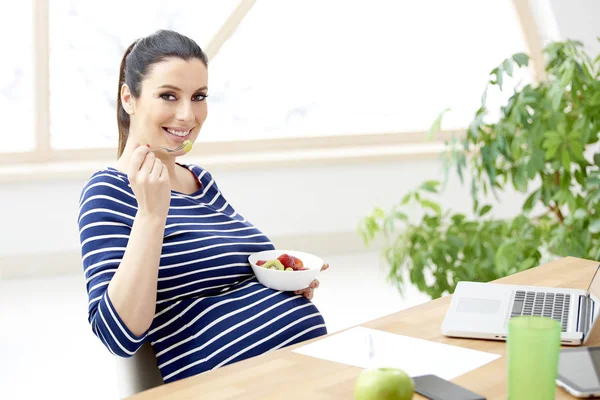 Mulher Grávida Bonita Comendo Uma Tigela Salada Frutas Enquanto Sentada — Fotografia de Stock