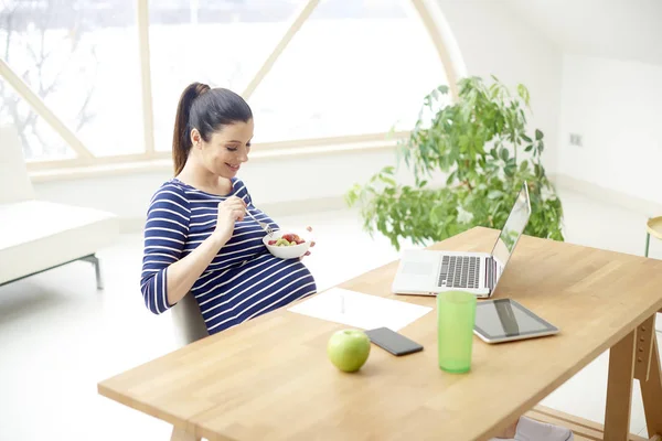 Hermosa Joven Embarazada Comiendo Tazón Ensalada Frutas Mientras Sienta Frente — Foto de Stock