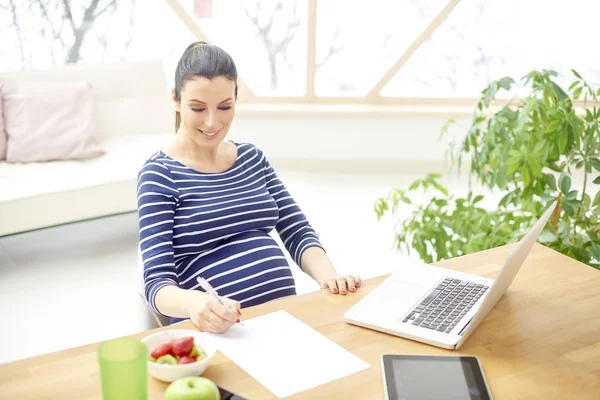 Zelfverzekerde Jonge Zwangere Vrouw Zit Achter Laptop Doet Wat Papierwerk Stockafbeelding