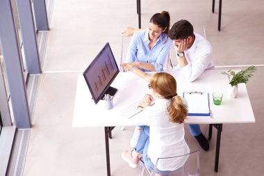 En iyi yatırım danışmanı iş kadını ofisteki masasında oturan gülümseyen genç çifte sunum yapıyor..