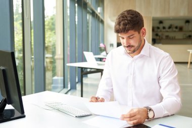 İşadamı ofiste evrak işleriyle uğraşıyor. 