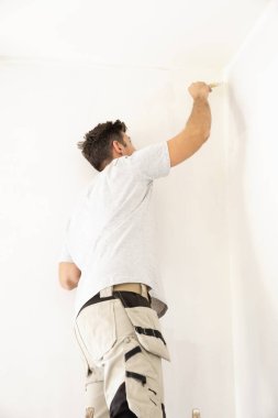 Çadırın duvarını boyayan genç adamın fotoğrafı.