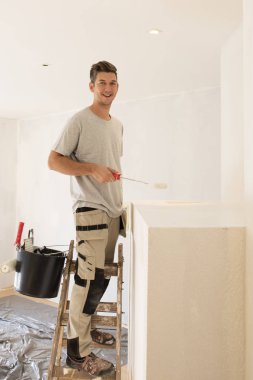 Daireyi boyayan profesyonel bir müteahhit.