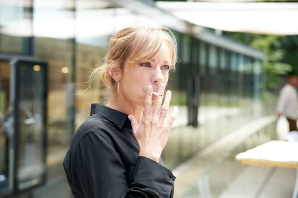 Middle aged woman smoking cigarette