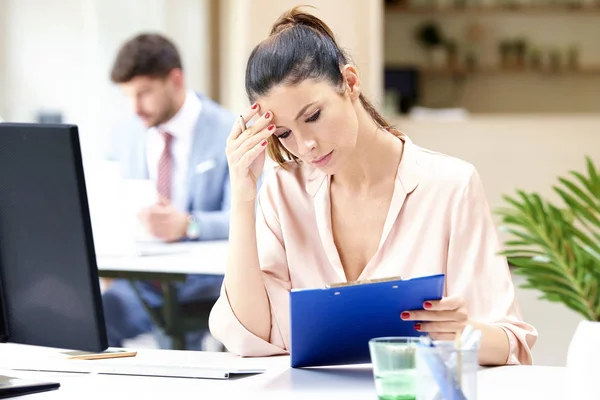 Ofis masasında çalışan endişeli iş kadını. — Stok fotoğraf