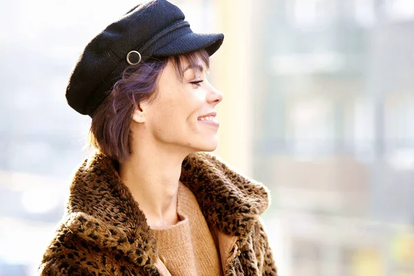 Şapka ve ceket giyen çekici genç bir kadın. — Stok fotoğraf