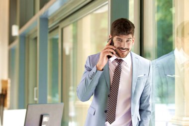 Ofiste dikilip iş görüşmesi yaparken takım elbise ve kravat takan yakışıklı genç işadamını vurdu..