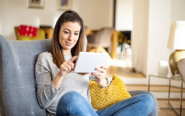 Mujer feliz usando tableta digital mientras se relaja en casa en el s — Foto de Stock