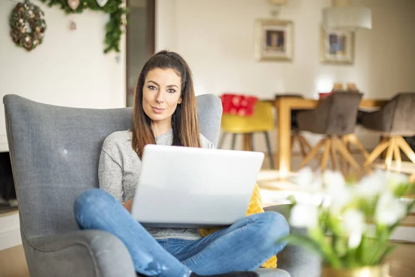 Mujer de negocios casual usando el ordenador portátil mientras trabaja en línea desde casa — Foto de Stock