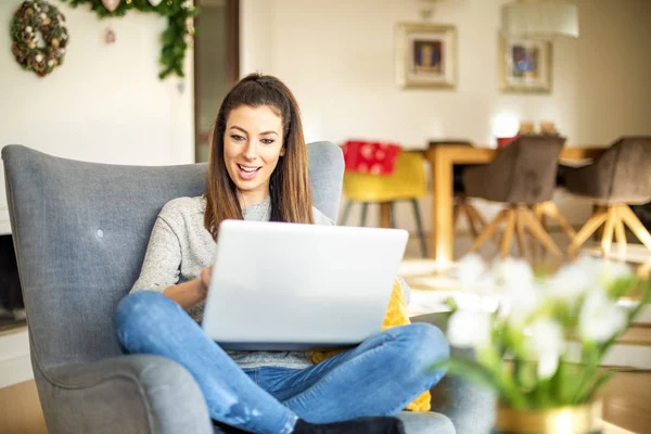 Mujer de negocios casual usando el ordenador portátil mientras trabaja en línea desde casa — Foto de Stock