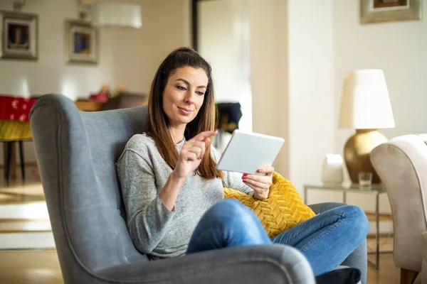 Mujer atractiva con tableta digital relajante en casa — Foto de Stock