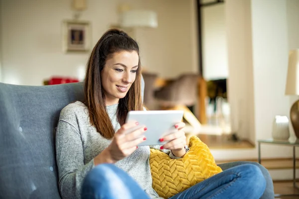 Mujer atractiva con tableta digital relajante en casa — Foto de Stock