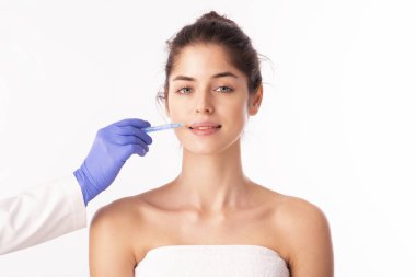 Portrait shot of an attractive woman receiving botox treatment for prevention. Isolated on white background. 