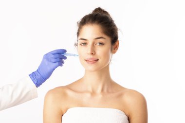 Portrait shot of an attractive woman receiving botox treatment for prevention. Isolated on white background. 