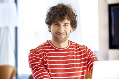 Kendine güvenen ve mutlu bir adamın laptopunun arkasında çalışırken çekilmiş yakın plan fotoğrafı..