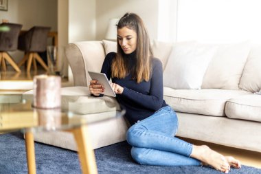 Dokunmatik defteri evde dinlenen çekici bir kadın. 