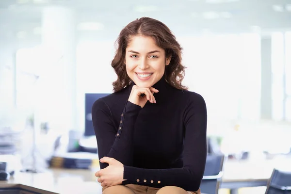 Joven empresaria confiada mirando la cámara y sonriendo mientras —  Fotos de Stock