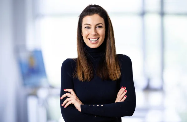 Attraktive Geschäftsfrau blickt in die Kamera und lächelt dabei — Stockfoto