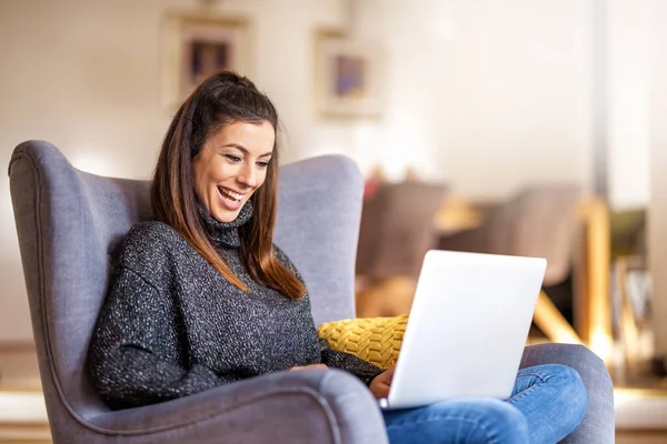 Happ jeune femme en utilisant un ordinateur portable tout en travaillant à la maison — Photo