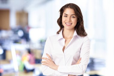 Ofiste dikilirken beyaz gömlek giyen çekici bir finans işkadını asistanı portresi..