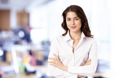 Ofiste dikilirken beyaz gömlek giyen çekici bir finans işkadını asistanı portresi..