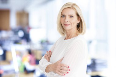 Ofiste kameraya bakıp gülümseyen güzel sarışın iş kadınının yakın plan portresi.. 