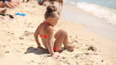 Kumsalda oynayan küçük kız.