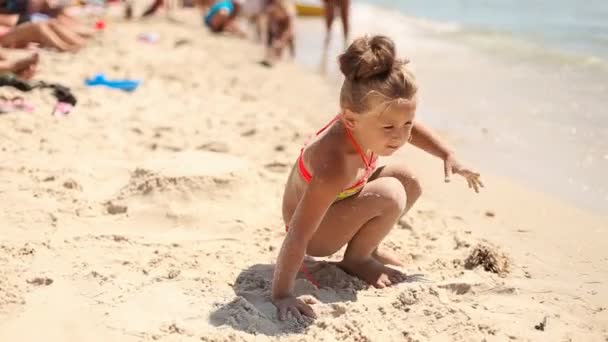 Klein meisje spelen op het strand — Stockvideo