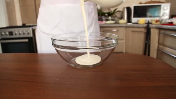 Szakács ömlött a tejszínt egy tálba — Stock videók