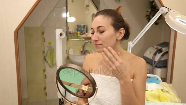 Vrouw kijkt in de spiegel — Stockvideo