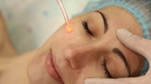 Reiniging van het gezicht van een vrouw met behulp van nieuwe technologieën — Stockvideo