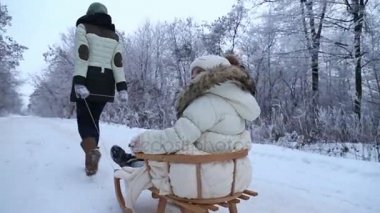 Anne kızı bir kızak üzerinde rulo