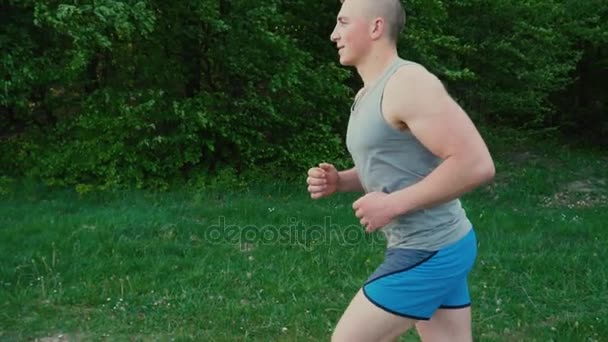 El tipo corre cerca del bosque — Vídeo de stock