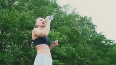 Kız şişeden su içiyor.